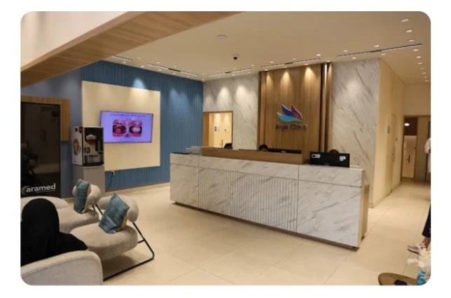 Arya Medical Center reception desk, styled with marble and warm wood finishes, reflecting the site's visual identity